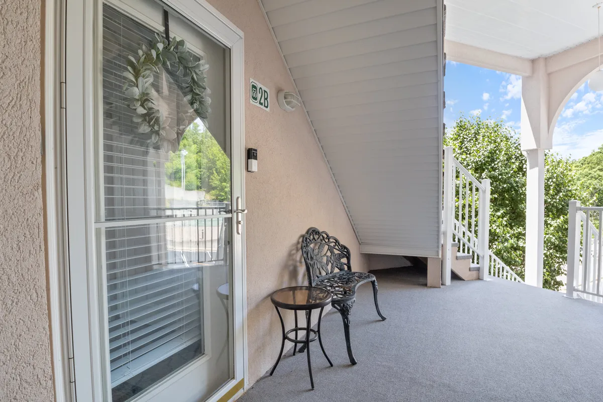 A welcoming front door adorned with a decorative wreath, a cozy bench, and a small table set the stage for secure entry. The inviting entryway hints at thoughtful touches and a sense of safety and comfort upon arrival.