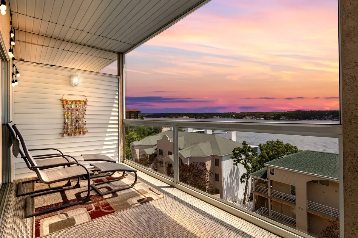 A tranquil exterior setting with lounge chairs arranged to face a shimmering lake, set against a stunning sunset sky. The peaceful ambiance invites relaxation and stargazing, suggesting the perfect end to a day of lakeside fun.