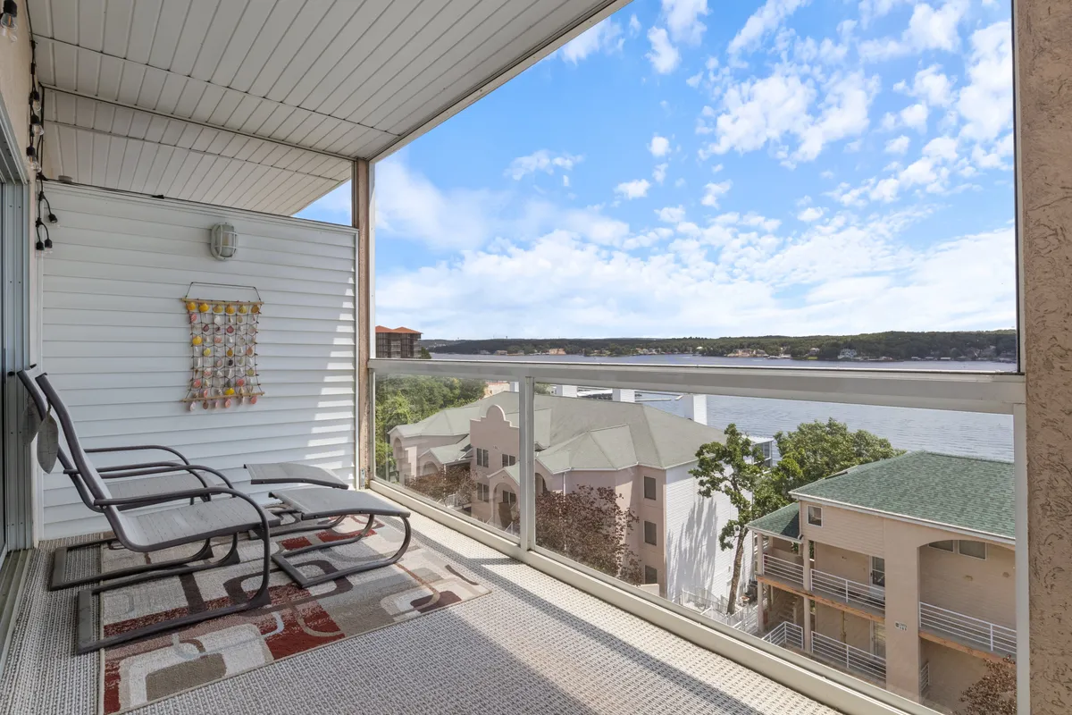 A private balcony featuring comfortable chairs, a decorative hanging, and a stunning view of the river. The scene suggests a peaceful spot for sipping coffee, reading a book, or savoring sunsets while overlooking the waterway.